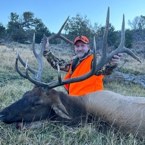 A hunter holding the antlers of his bull elk after a successful hunt